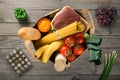 Full paper bag of groceries on wooden background