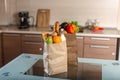 Full paper bags with foods on the table on the background of the kitchen. Healthy eco products for a balanced diet