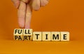 Full or part time symbol. Businessman turns wooden cubes and changes words `full-time` to `part-time`. Beautiful orange table, Royalty Free Stock Photo