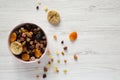 Full pink bowl of dried fruits and nuts on a white wooden background, top view. Overhead, from above, flat lay. Copy space Royalty Free Stock Photo