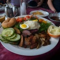 A full plate with egg, cucumber, tomato, roll, rice and more