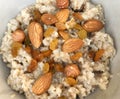 Full plate of oatmeal with nuts and raisins on a wooden table