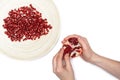 Full plate of peeled pomegranate seeds and a man de-seeding gran Royalty Free Stock Photo