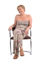 Full portrait of middle aged woman sitting on a vintage chair on Royalty Free Stock Photo