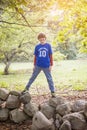 full portrait of a smiling ten year old boy outside standing under a tree and sun Royalty Free Stock Photo