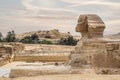 Full profile of Great Sphinx including pyramids of Khafre in the background on a cloudy sky day in Giza, Cairo, Egypt. no people. Royalty Free Stock Photo