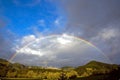 Full rainbow over forest hills Royalty Free Stock Photo