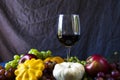 Full red wine glass and autumn and fall harvest, pumpkin, apple and grape Royalty Free Stock Photo