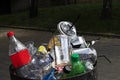 full roadside trash can with disposable cups, plastic bottles and other things. Royalty Free Stock Photo