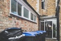 Full rubbish and waste bins seen at the back of a restaurant, awaiting to be collected. Royalty Free Stock Photo