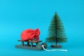 Full Santa Claus red bag on sleigh by fir tree isolated on blue background. Christmas gift concept Royalty Free Stock Photo