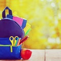 Full School backpack with red apple on wooden and autumn nature background Royalty Free Stock Photo