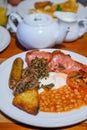 Full Scottish breakfast with bacon, fried egg, beans, tomato, roasted sausage, pudding, hash browns and haggis Royalty Free Stock Photo