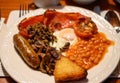 Full Scottish breakfast with bacon, fried egg, beans, tomato, roasted sausage, pudding, hash browns and haggis Royalty Free Stock Photo