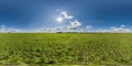 full seamless 360 hdri panorama view among farming field with sun and clouds in overcast sky in equirectangular spherical