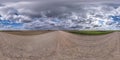 Full seamless spherical hdri panorama 360 degrees angle view on gravel road among fields in spring day with storm clouds before Royalty Free Stock Photo