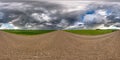 Full seamless spherical hdri panorama 360 degrees angle view on wet gravel road among fields in spring day with storm clouds after Royalty Free Stock Photo