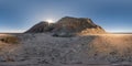 Full seamless spherical hdri 360 panorama view of sunset in desert with sun shines from behind the mountain on coast of sea in Royalty Free Stock Photo