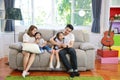 Full shot happy Asian family, father, mother daughter and son singing karaoke on the sofa in the living room with happy smiling Royalty Free Stock Photo