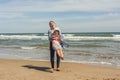 Full shot teenager and her little sister playing in the sea shore of the beach.