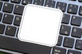 Full simple blank white square label on a laptop computer keyboard, empty sticker template for logo design, closeup detail, modern