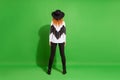 Full size back photo of red hairdo lady stand wear hat shirt trousers shoes isolated on green background