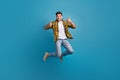 Full size body photo of young funky positive overjoyed guy thumbs up jumping showing good feedback rate isolated on blue