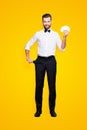 Full size body portrait of stylish joyful magician with hairstyle having set of cards in hands and demonstrate empty