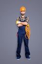 Full size body portrait of virile brutal electrician with bristle in overall, shirt, holding rolled cable in hand Royalty Free Stock Photo