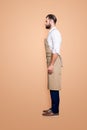 Full size fullbody, side view profile portrait snap of handsome attractive barber in uniform, isolated over grey