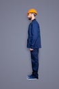 Full size fullbody snap with legs, profile portrait of calm handsome repairer in blue uniform, isolated on grey