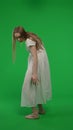 Full-size half turn vertical green screen, chroma key shot of a posessed female, woman figure, ghost, poltergeist