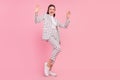 Full size image lady feeling young enjoying dancing wear checkered suit isolated on pink color background