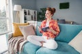 Full size photo of adorable positive girl sit barefoot couch hold book look window fantasize apartment indoors Royalty Free Stock Photo