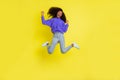 Full size photo of astonished dark skin girl jumping closed eyes open mouth fists up isolated on yellow color background