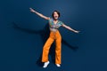 Full size photo of attractive young woman hands wings play fight wear trendy flared pants clothes isolated on dark blue Royalty Free Stock Photo