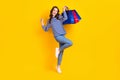 Full size photo of attractive young woman huge sales raise shopping bags dressed stylish striped look isolated on yellow