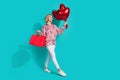 Full size photo of attractive young woman shopping bags heart balloons wear trendy pink print clothes isolated on cyan Royalty Free Stock Photo