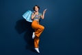 Full size photo of attractive young woman shopping bags point empty space wear trendy flared pants isolated on dark blue Royalty Free Stock Photo