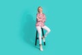 Full size photo of attractive young woman sitting chair crossed arms dressed stylish pink clothes  on aquamarine Royalty Free Stock Photo