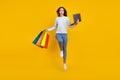 Full size photo of brown amazed haired stylish trendy girl wear sweater jeans hold laptop sale jump isolated on yellow
