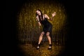 Full size photo of brown optimistic lady stand sing in mic wear black dress shoes  on dark gold color background Royalty Free Stock Photo