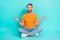 Full size photo of calm man muscular beard wear orange t-shirt jeans headphones sit in meditation pose isolated on teal