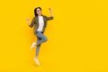 Full size photo of celebrate young lady jump wear eyewear shirt jeans sneakers isolated on yellow background Royalty Free Stock Photo
