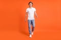 Full size photo of charming attractive happy man walk good mood wear casual clothes isolated on orange color background