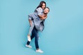 Full size photo of charming people hugging piggy-backing wearing denim jeans jackets over blue background