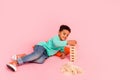 Full size photo of charming small boy play playroom wooden blocks tower dressed stylish cyan outfit isolated on pink Royalty Free Stock Photo