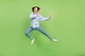 Full size photo of cheerful young nice happy woman jump up fighter amazed excited isolated on green color background