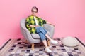 Full size photo of confident serious person with white gray hair dressed plaid shirt sit on armchair on pink