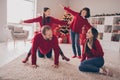 Full size photo of cool family play on carpet hands wings wear red jumpers jeans socks new year at house